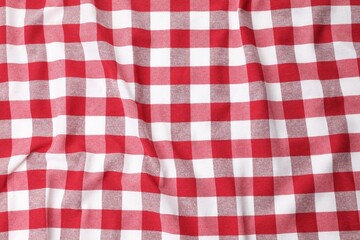 Crumpled checkered tablecloth as background, top view