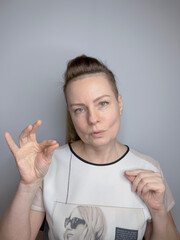 portrait of a mature woman with long hair pulled back in a ponytail and gesticulating with her hands
