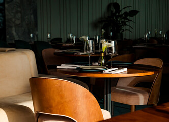 Stylish table setting in a cozy restaurant with dishes and furniture.in a minimalist style