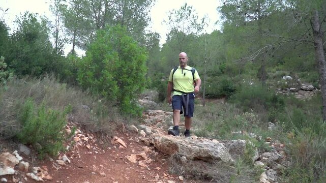 Slow motion, one man walking alone in the mounatin, healthy activity.