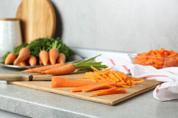 Pieces of fresh carrots on gray textured countertop, closeup