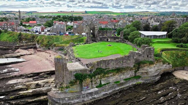Aerial view of Coastal, episcopal castle ruins with secret passages and dungeon in Scotland. St Andrews Castle residence of Scotland's leading bishop, cathedral and town of St Andrews view.