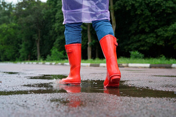 Woman in red rubber boots walking outdoors, closeup