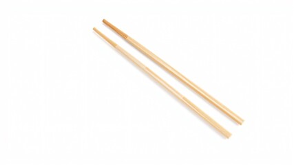 Obraz premium A pair of finely crafted wooden chopsticks lies on a simple white background, highlighting their smooth finish and traditional design, ideal for enhancing dining experiences