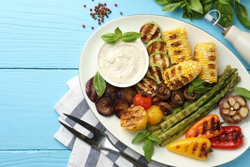 Delicious grilled vegetables served on light blue wooden table, flat lay