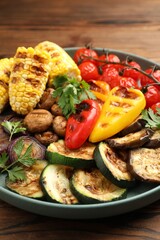 Delicious grilled vegetables on wooden table, closeup