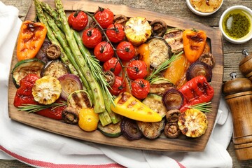 Delicious grilled vegetables served on wooden table, flat lay