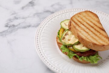 Tasty sandwich with grilled vegetables on white marble table, closeup. Space for text