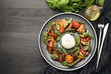 Tasty salad with grilled vegetables and mozzarella cheese served on black wooden table, flat lay. Space for text