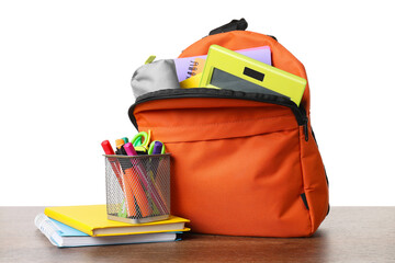 Backpack with different school stationery on wooden table against white background