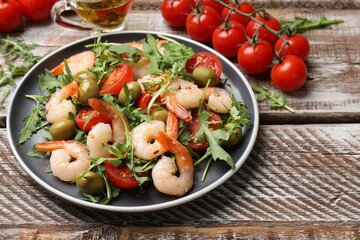 Delicious shrimp salad with tomatoes and olives on wooden table, closeup