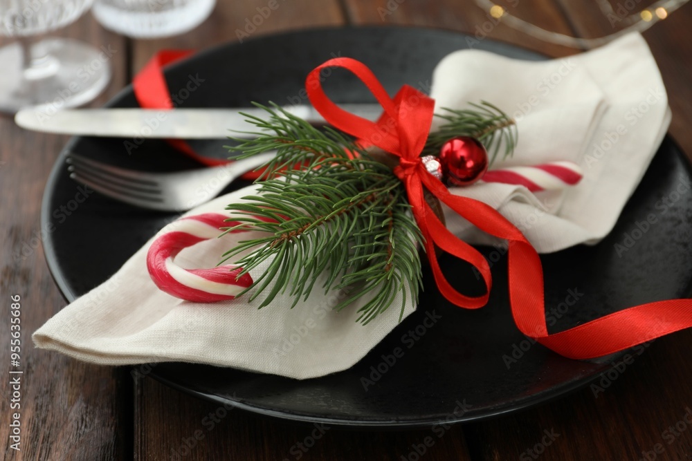 Poster Christmas setting with plate, cutlery, fir branches and ribbon on wooden table, closeup