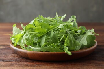 Fresh green arugula leaves on wooden table, closeup