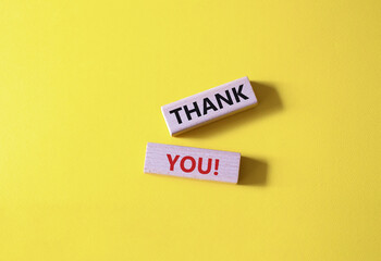 Thank you symbol. Wooden blocks with words Thank you. Beautiful yellow background. Business and Thank you concept. Copy space.