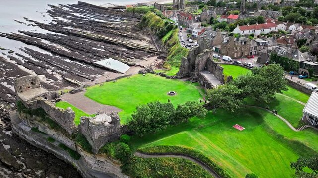 Aerial view of Coastal, episcopal castle ruins with secret passages and dungeon in Scotland. St Andrews Castle residence of Scotland's leading bishop, cathedral and town of St Andrews view.