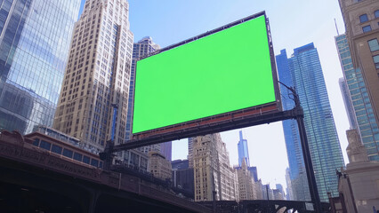 Blank green billboard screen in modern cityscape