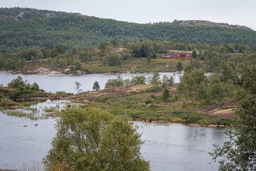 Norwegian lake landscape with lakes and red house in background