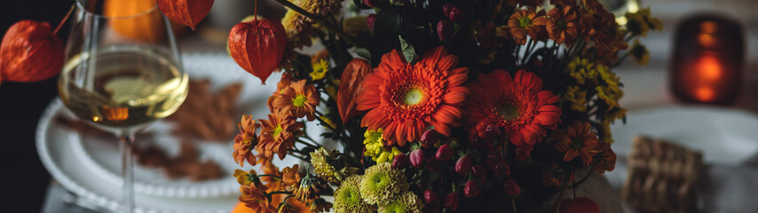 Atmospheric autumn elegant beautiful table setting with pumpkins for a wedding or thanksgiving family celebration. Fall decoration countryside rustic style, cozy home atmosphere , candles, wine banner