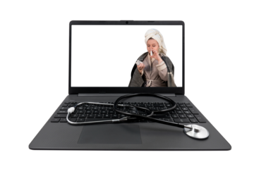 Laptop and medical stethoscope on a transparent background. On the laptop screen - a girl with cold symptoms injects a spray into her nose