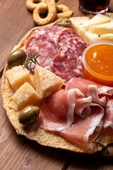 Tagliere con prosciutto crudo, parmigiano, salame e pecorino, antipasti italiani, gastronomia europea 