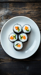 White plate on a dark wooden table features five salmon and cucumber sushi rolls