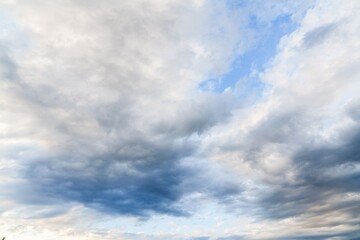 Obraz premium A stunning cloudscape showcasing a bright blue sky and dense white clouds illuminated by sunlight. This beautiful scene is perfect for various creative projects, adding a touch of drama and beauty.