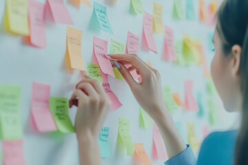Close up of a young marketing woman organizing ideas with colorful sticky notes in office