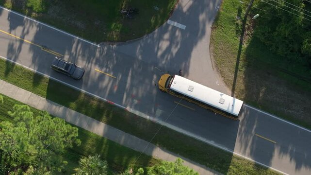 Students getting on yellow school bus at bus stop going to classes. Coming back to school in new educational year semester. Public school transportation in the USA.
