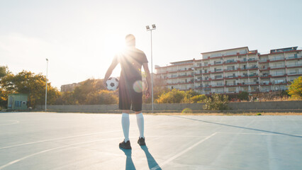 Soccer Player Holding A Ball In A Urban Pitch 