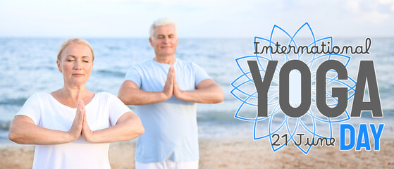 Mature couple practicing yoga at sea resort