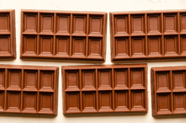 Background of milk chocolate bars in rectangular format. Top view. 