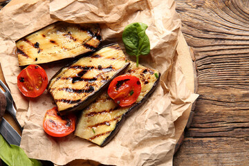 Delicious grilled eggplants and tomatoes on wooden background