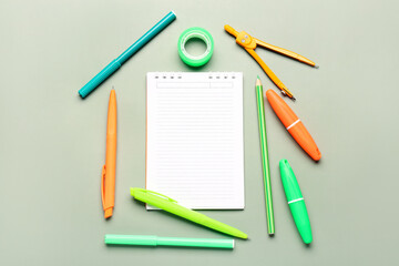 Open notebook with different stationery on grey background