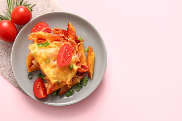 Plate of pasta with tomato sauce and cheese on pink background
