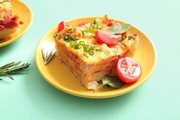 Plate of pasta with tomato sauce and cheese on turquoise background
