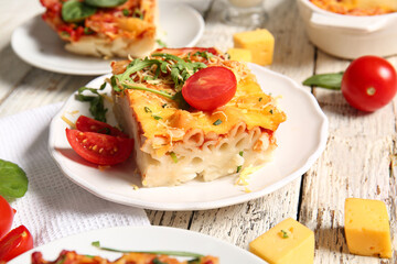 Plates of pasta with tomato sauce and cheese on white wooden background