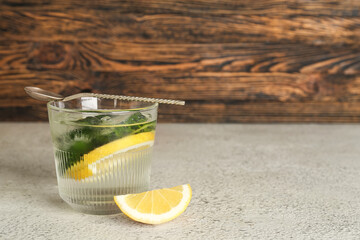 Glass of lemonade with cucumber on white table