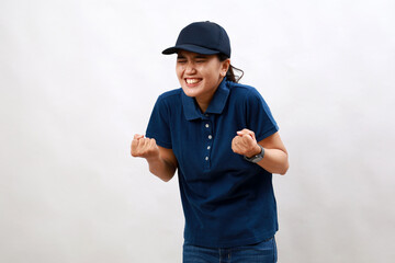 Young asian woman courier wearing delivery uniform and cap very happy and excited doing winner gesture with arms raised, smiling and screaming for success. celebration concept.