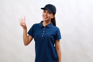 Young asian woman courier wearing delivery uniform and cap showing and pointing up with finger number three while smiling confident and happy.