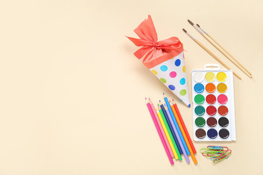 Red school cone with different stationery on pale orange background - Powered by Adobe