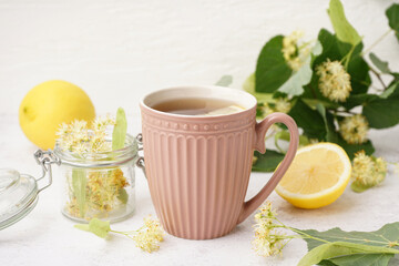 Cup of linden tea with lemon on white background