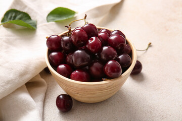 Bowl with sweet cherries on white background