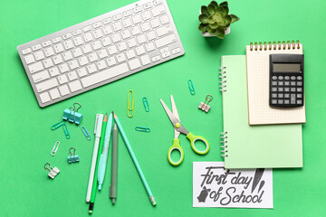 Card with text FIRST DAY OF SCHOOL, different stationery and computer keyboard on green background