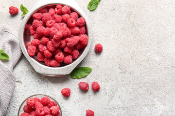 Metal plate with fresh raspberries and mint on grey background