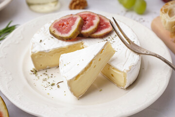 Plate with pieces of tasty Camembert cheese on grey background