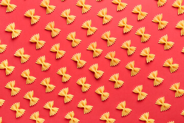 Frame made of uncooked farfalle pasta on red background