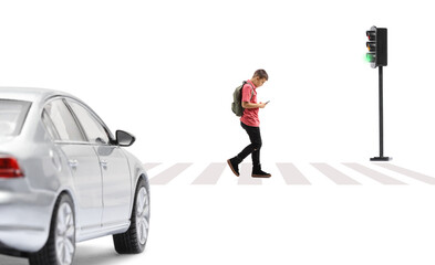 Full length profile shot of a schoolboy crossing a street and looking at a mobile phone