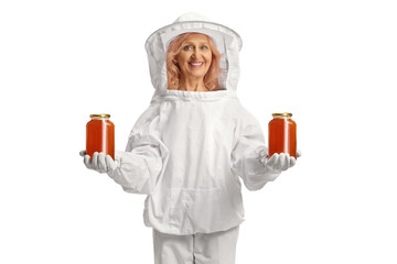 Woman bee keeper holding jars of honey and smiling