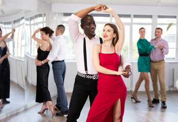 During rehearsal of reporting concert, woman with African-American man participants of dance...