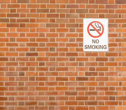 No smoking sign attached to a brick built wall anti - smoking symbol.